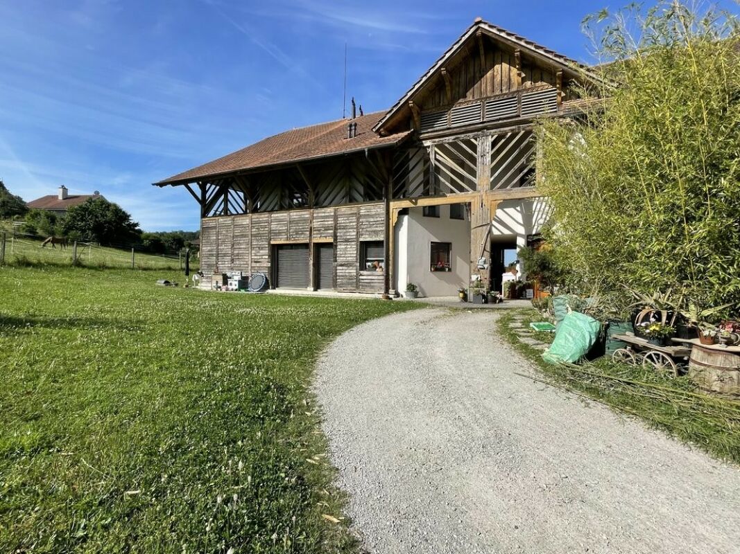 Ländliches Haus mit Holzfassade und großem Walmdach