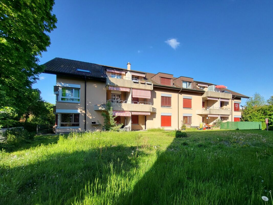 Mehrfamilienhaus mit Balkonen und großer Grünfläche