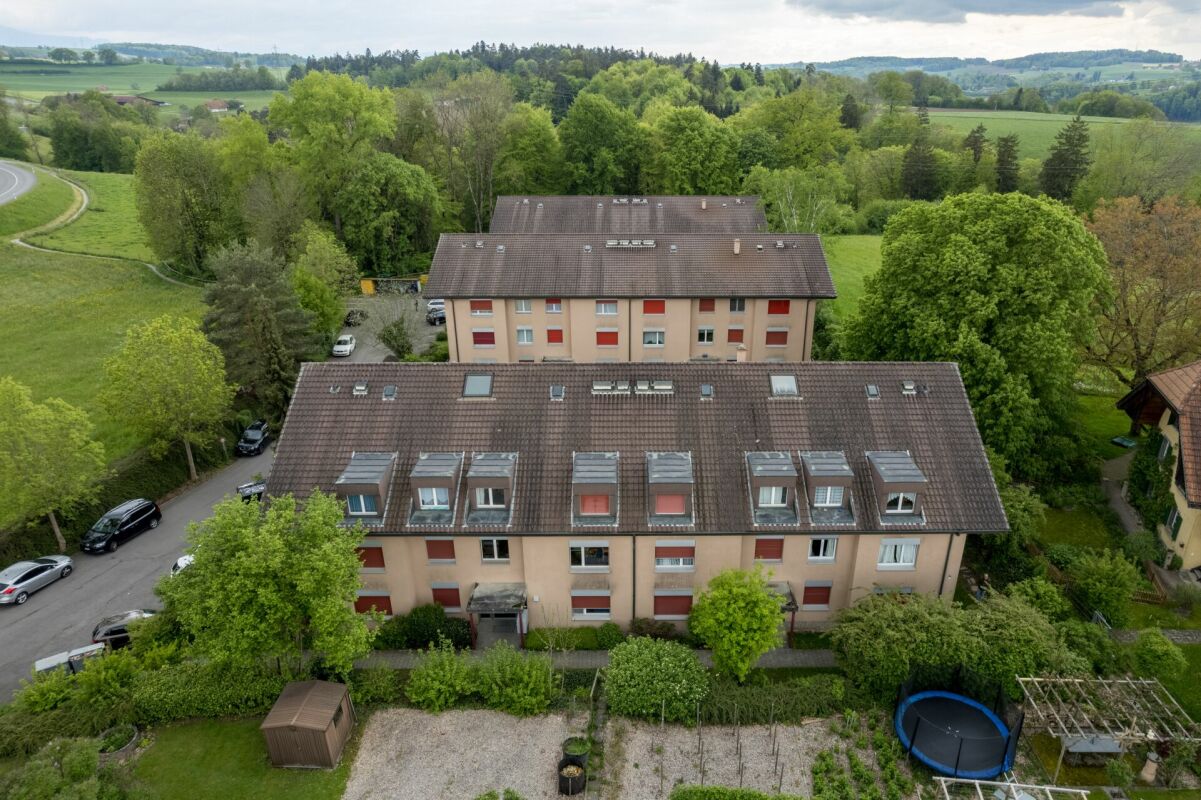 Luftaufnahme eines Mehrfamilienhauses in grüner Umgebung