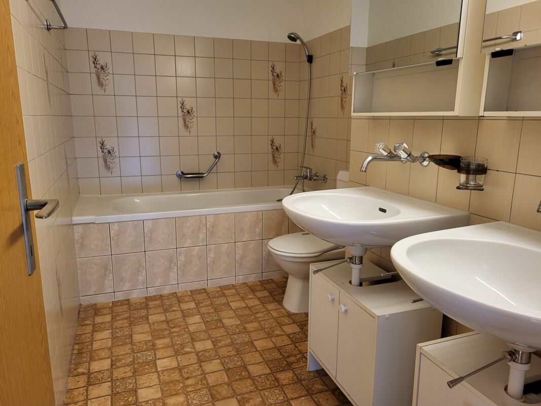 Badezimmer mit Doppelwaschtisch und Badewanne