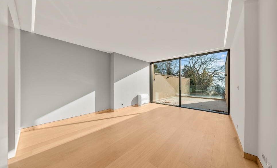 Leerer, heller Wohnraum mit großer Glasfront
