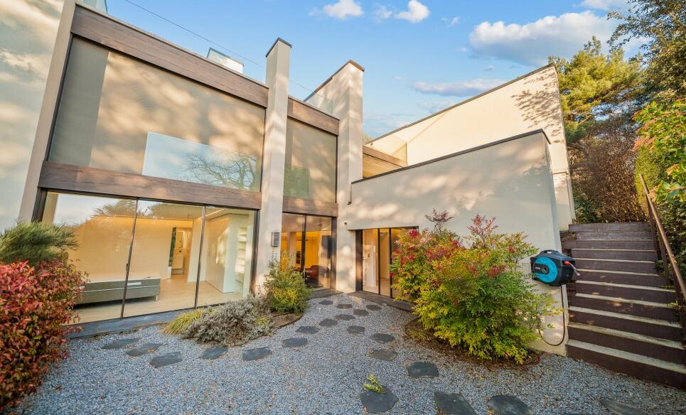 Modernes Haus mit großer Glasfassade und Gartenzugang