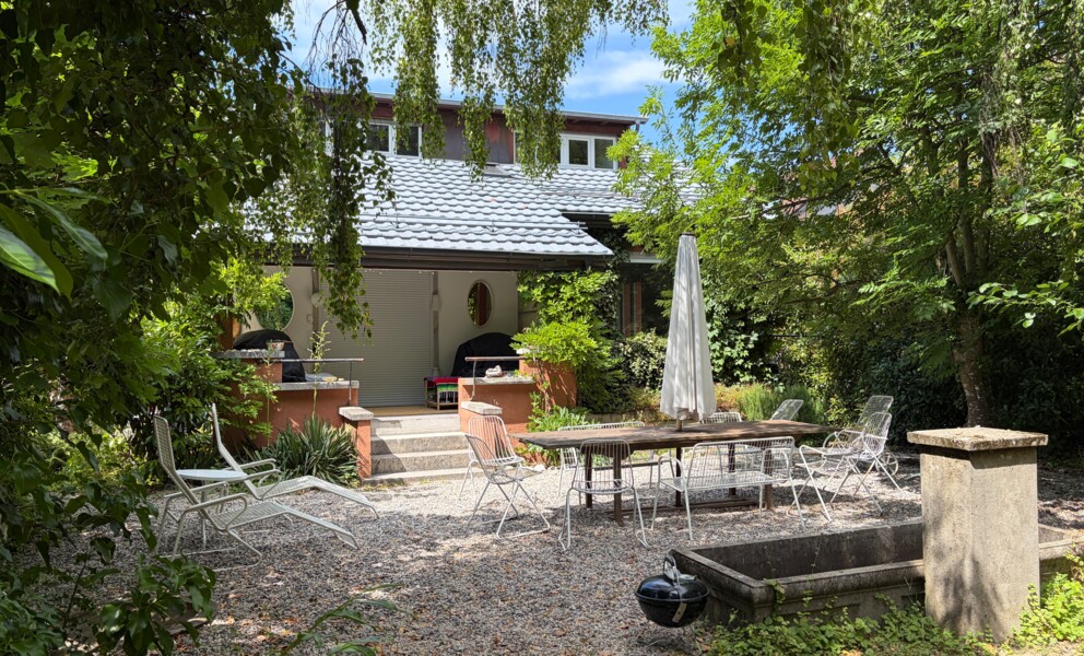 Garten mit Terrasse und Hausfassade