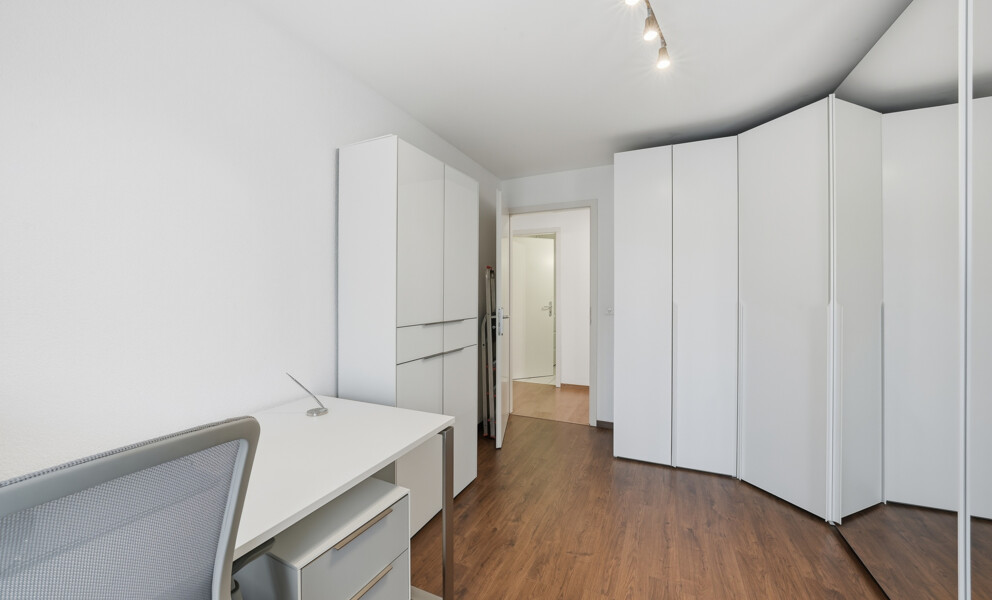 Kleines Ankleidezimmer mit weißen Schränken