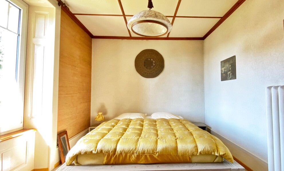 Helles Schlafzimmer mit gelbem Bett und Holzdetails