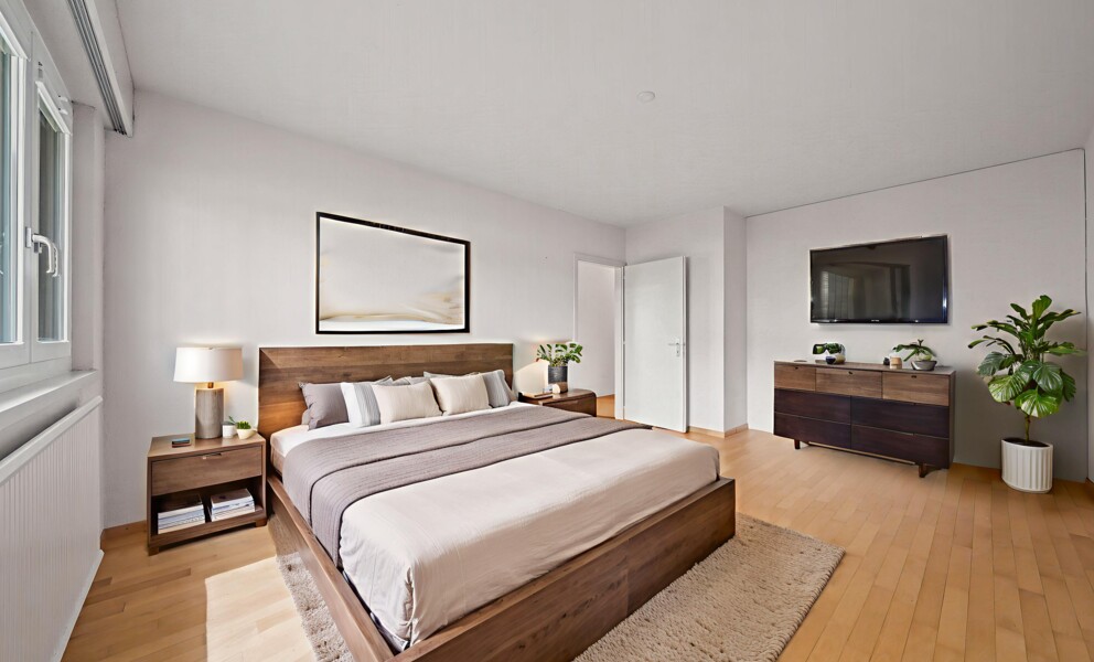 Helles, modernes Schlafzimmer mit Holzbett und TV