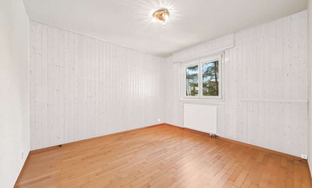 Heller leerer Raum mit Holzverkleidung und Fenster