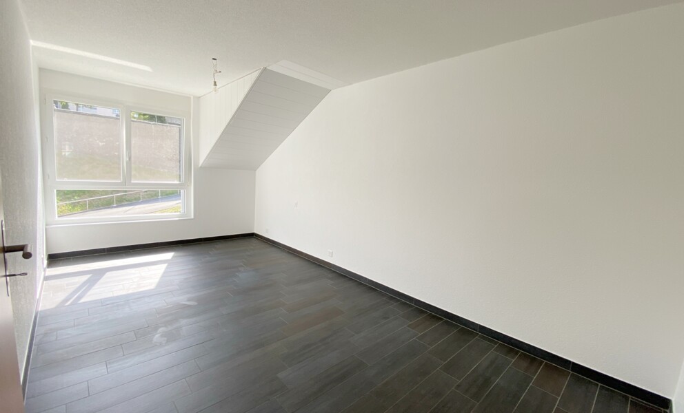 Helles, leeres Zimmer mit großem Fenster