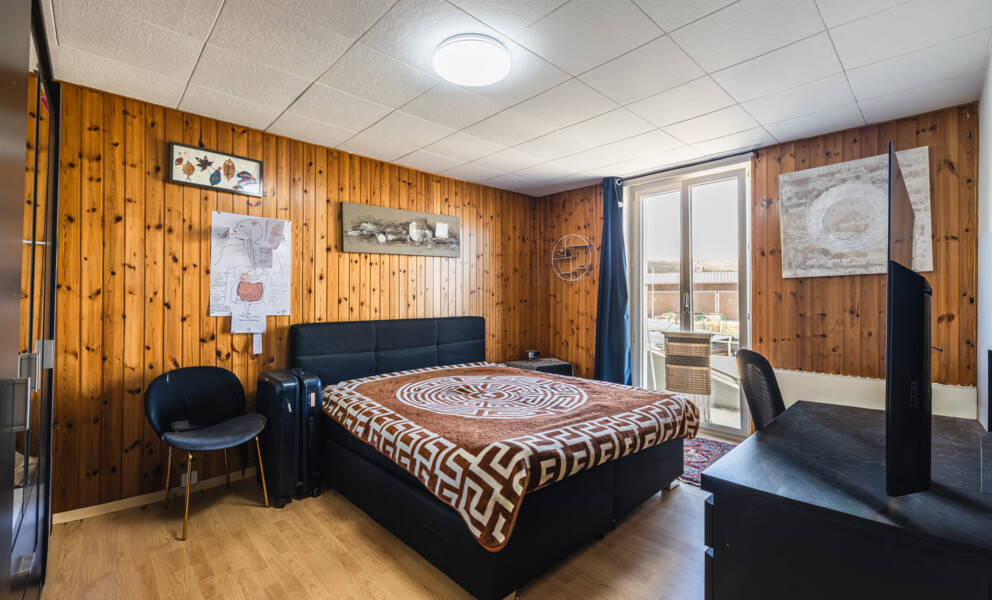 Gemütliches Schlafzimmer mit Holzvertäfelung