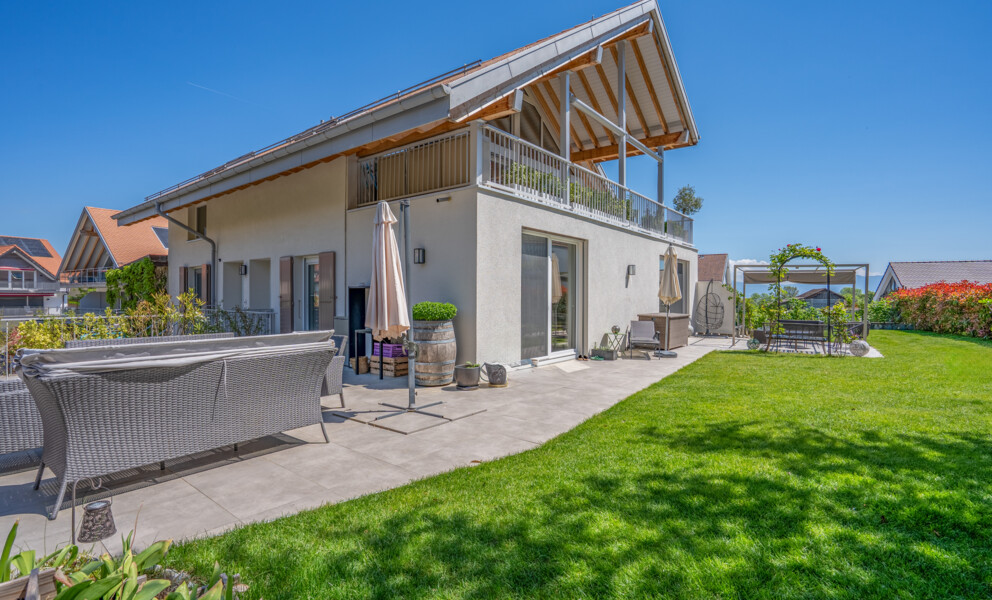 Moderne Gartenansicht mit Terrasse und Balkon
