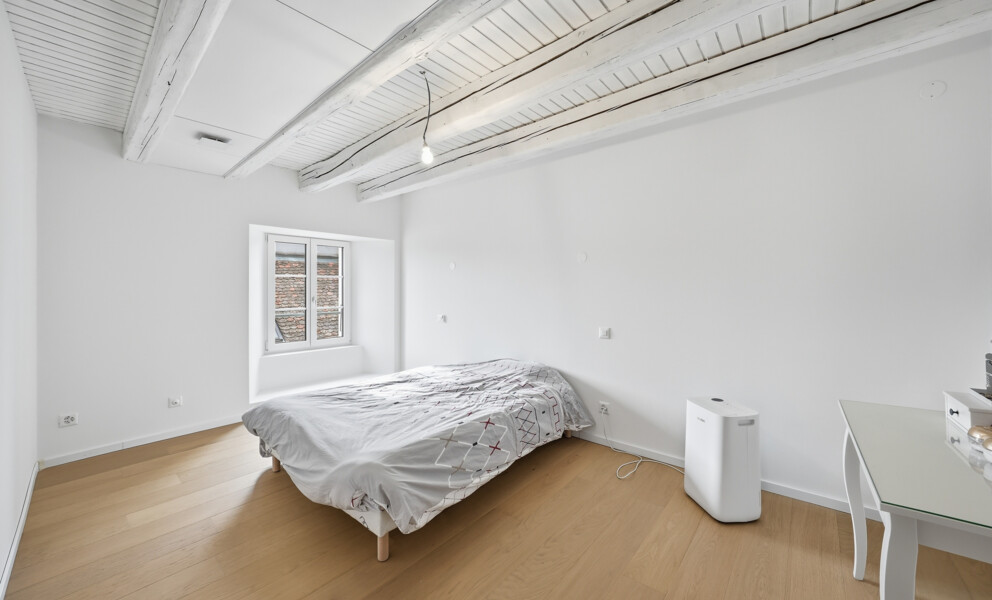 Helles Schlafzimmer mit sichtbaren Holzbalken
