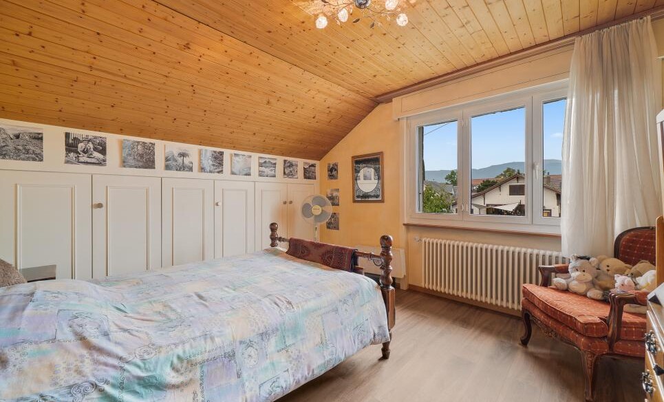 Gemütliches Schlafzimmer mit Holzdecke und Bergblick