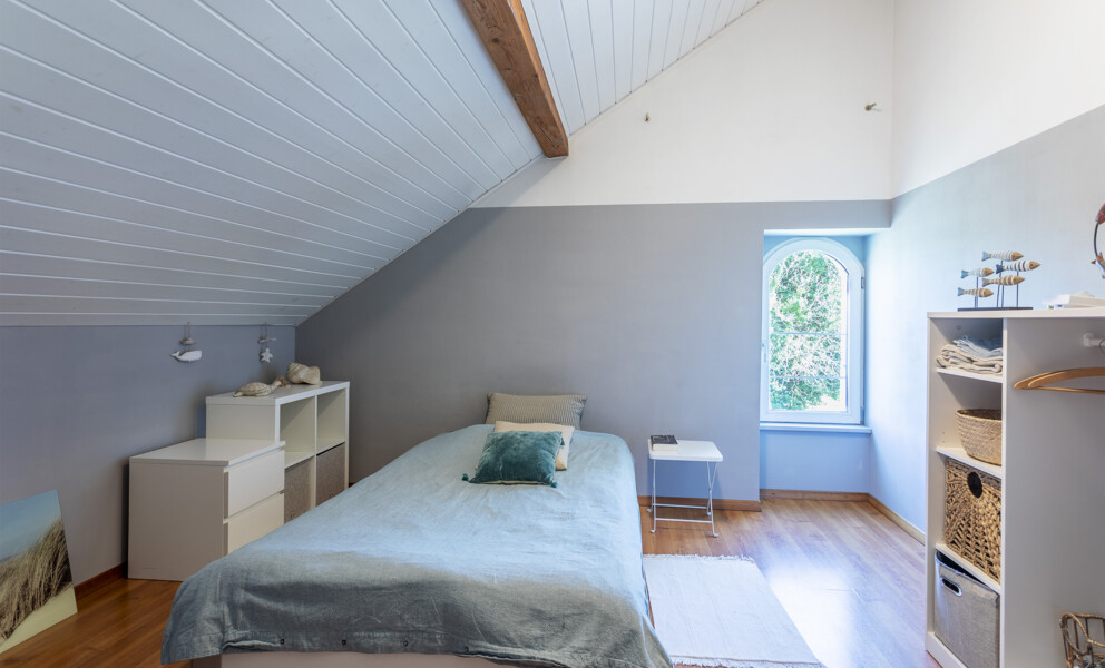 Helles Dachgeschoss-Schlafzimmer mit gemütlicher Einrichtung