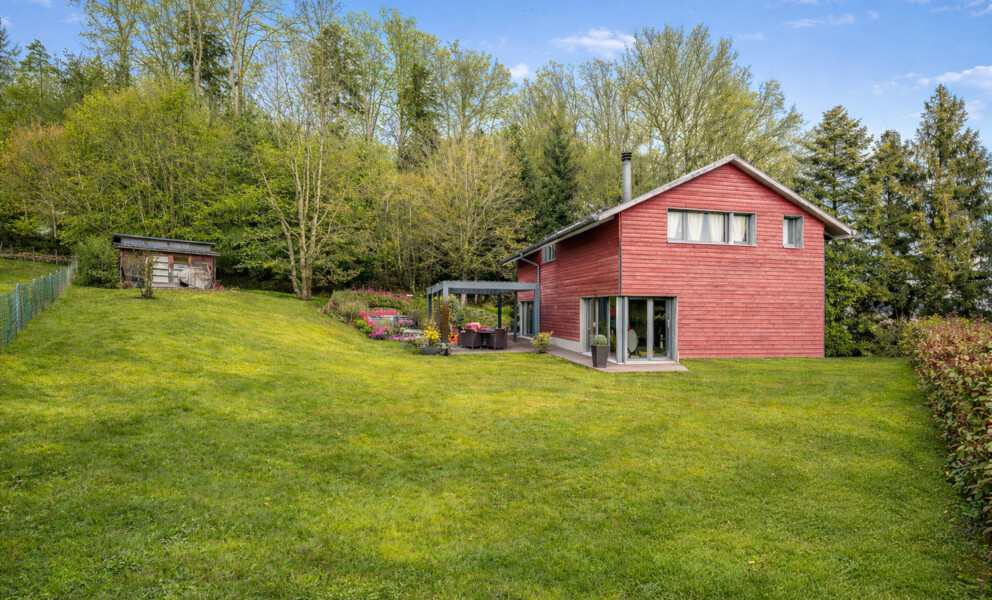 Rotes Holzhaus mit großer Rasenfläche