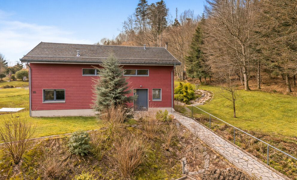 Rot verkleidetes Einfamilienhaus mit Garten