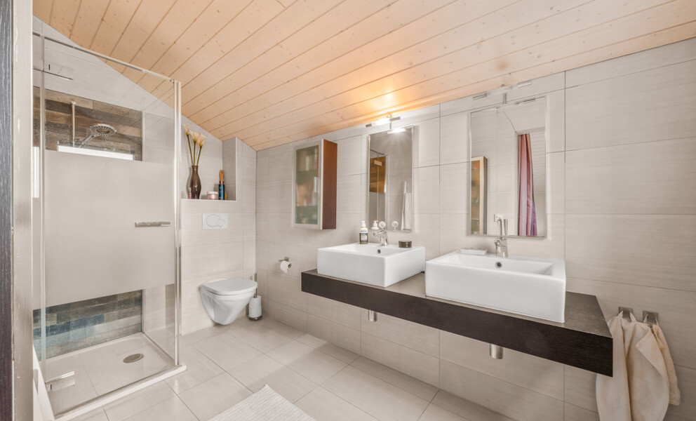 Modernes Badezimmer mit Glasdusche und Doppelwaschbecken