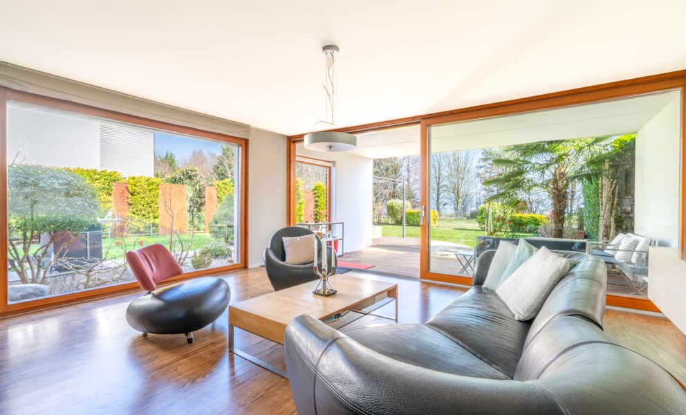 Großzügiges Wohnzimmer mit Panoramafenstern und Gartenzugang