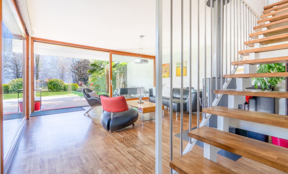 Heller Wohnbereich mit offener Treppe und bodentiefen Glasflächen
