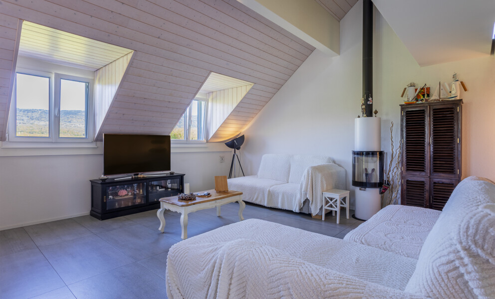 Dachgeschoss-Wohnzimmer mit Kamin und TV