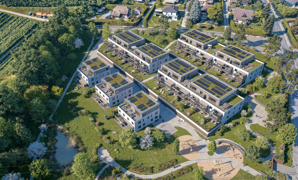 Luftaufnahme einer modernen Wohnanlage mit begrünten Dächern und Solarflächen