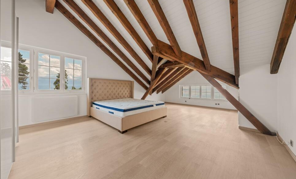 Dachgeschoss-Schlafzimmer mit sichtbaren Holzbalken