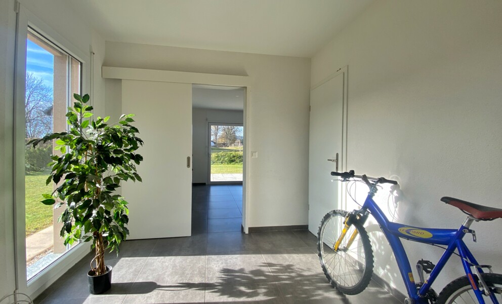 Heller Eingangsbereich mit Schiebetür und Fahrrad