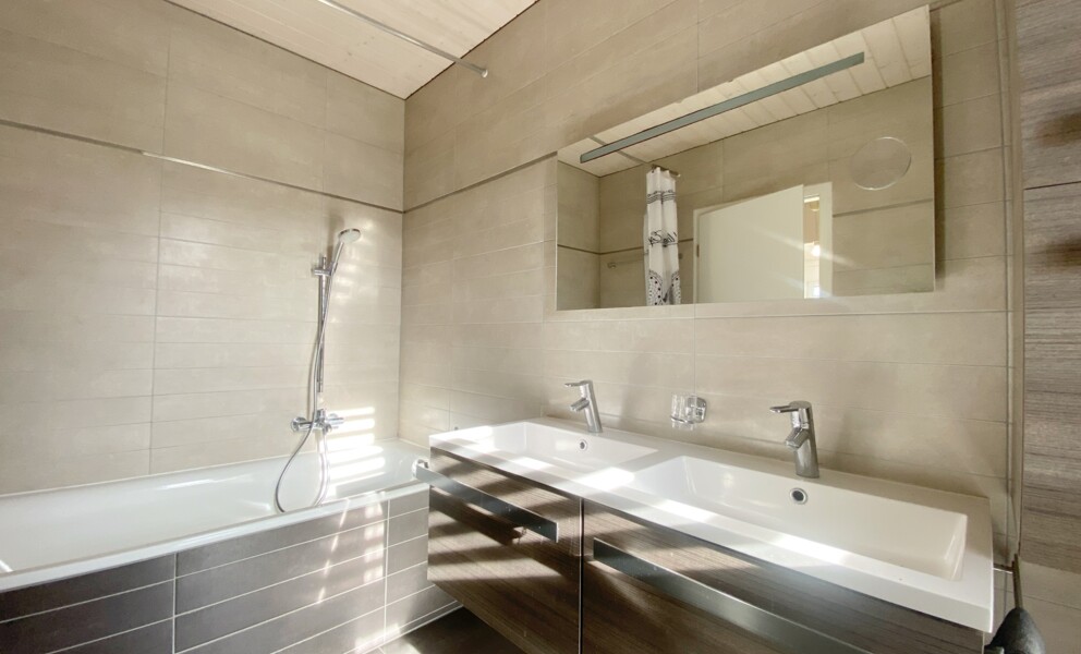 Helles, modernes Badezimmer mit Wanne und Doppelwaschtisch
