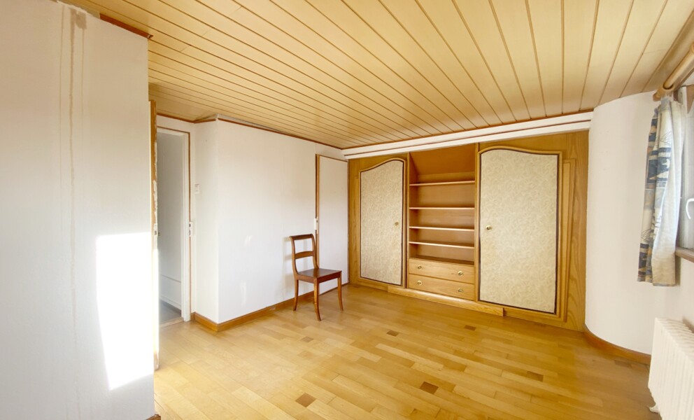 Helles Zimmer mit Holzvertäfelung und Einbauschrank