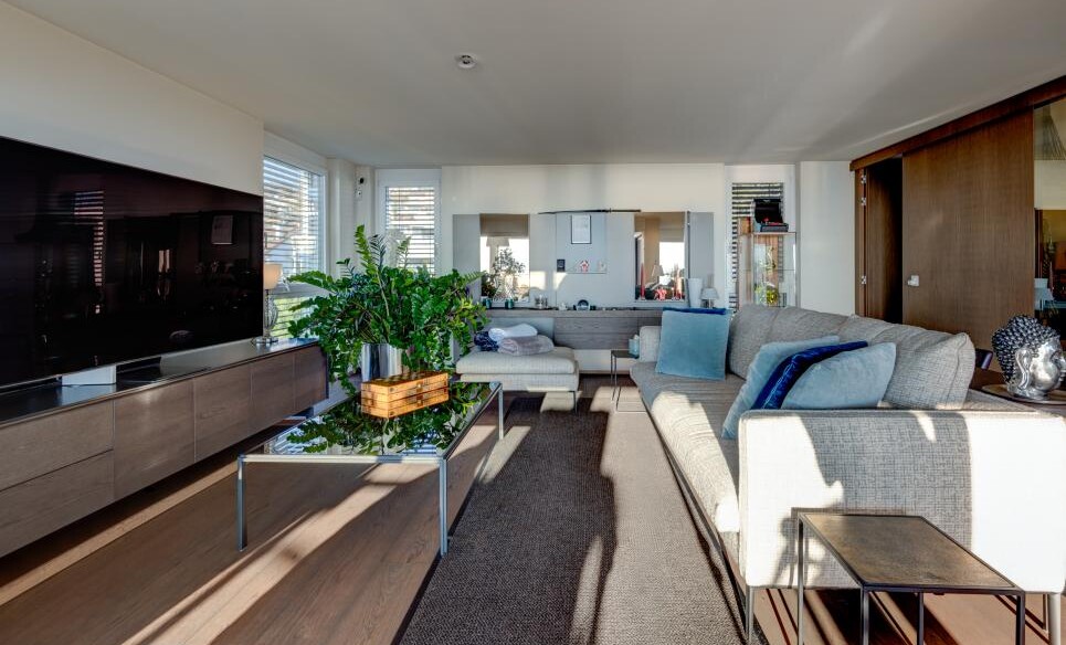 Modernes Wohnzimmer mit großem TV und Sitzbereich