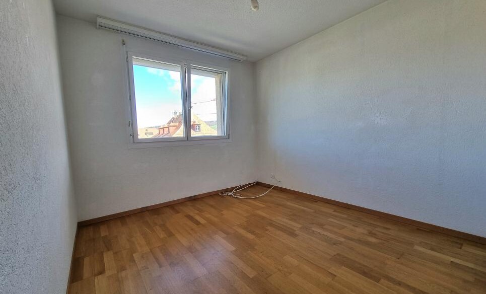 Leeres Zimmer mit Fenster und Parkettboden