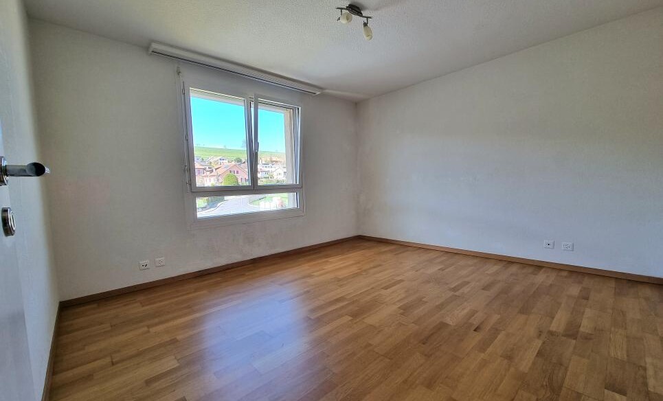 Leeres Schlafzimmer mit Parkett und Fensterblick