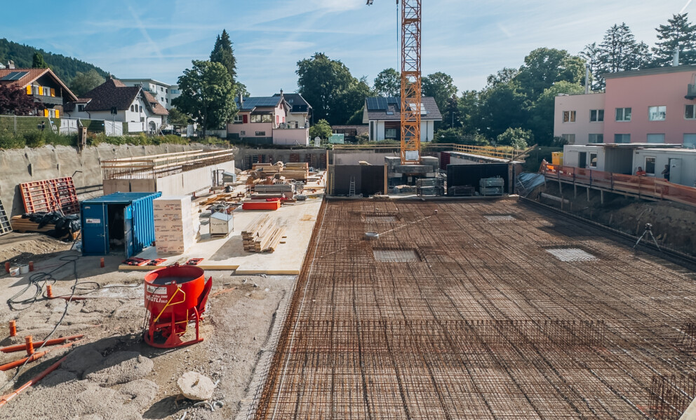 Baustelle eines Wohngebäudes mit Fundament und Kran
