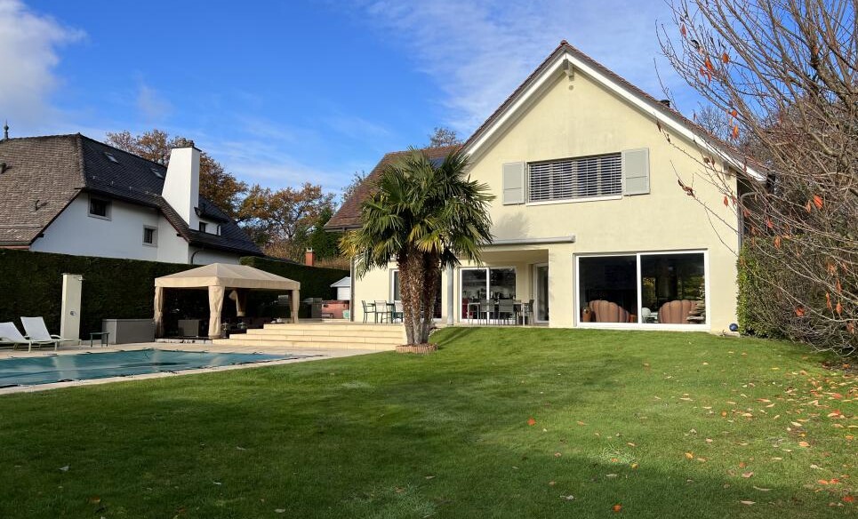 Gartenansicht eines Einfamilienhauses mit Pool und Terrasse