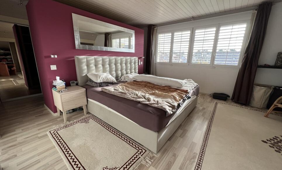 Schlafzimmer mit Bett und großen Fenstern