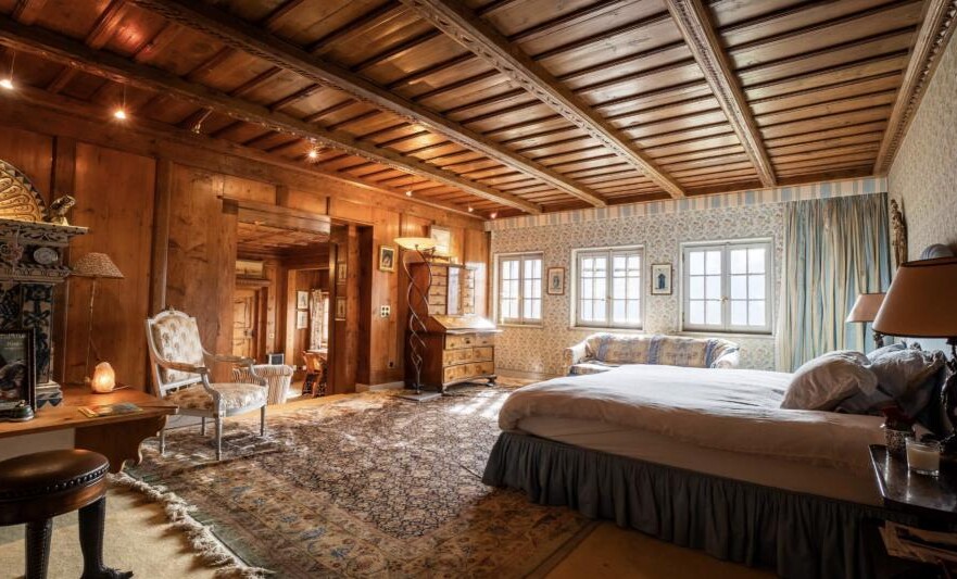 Rustikal eingerichtetes Schlafzimmer mit Holzvertäfelung
