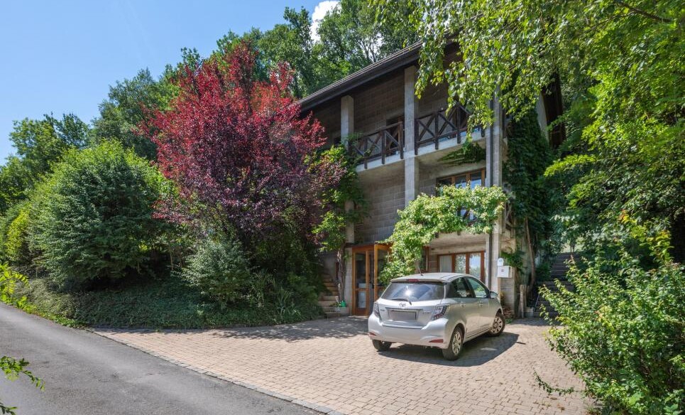 Bewachsenes Wohnhaus mit Einfahrt