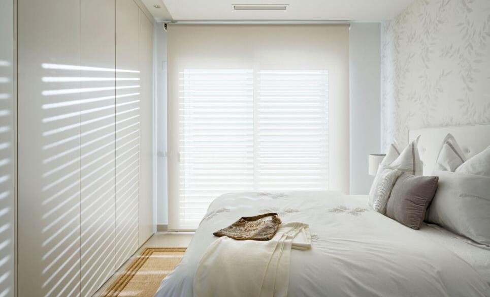 Helles, schlichtes Schlafzimmer mit Einbauschrank und großem Fenster