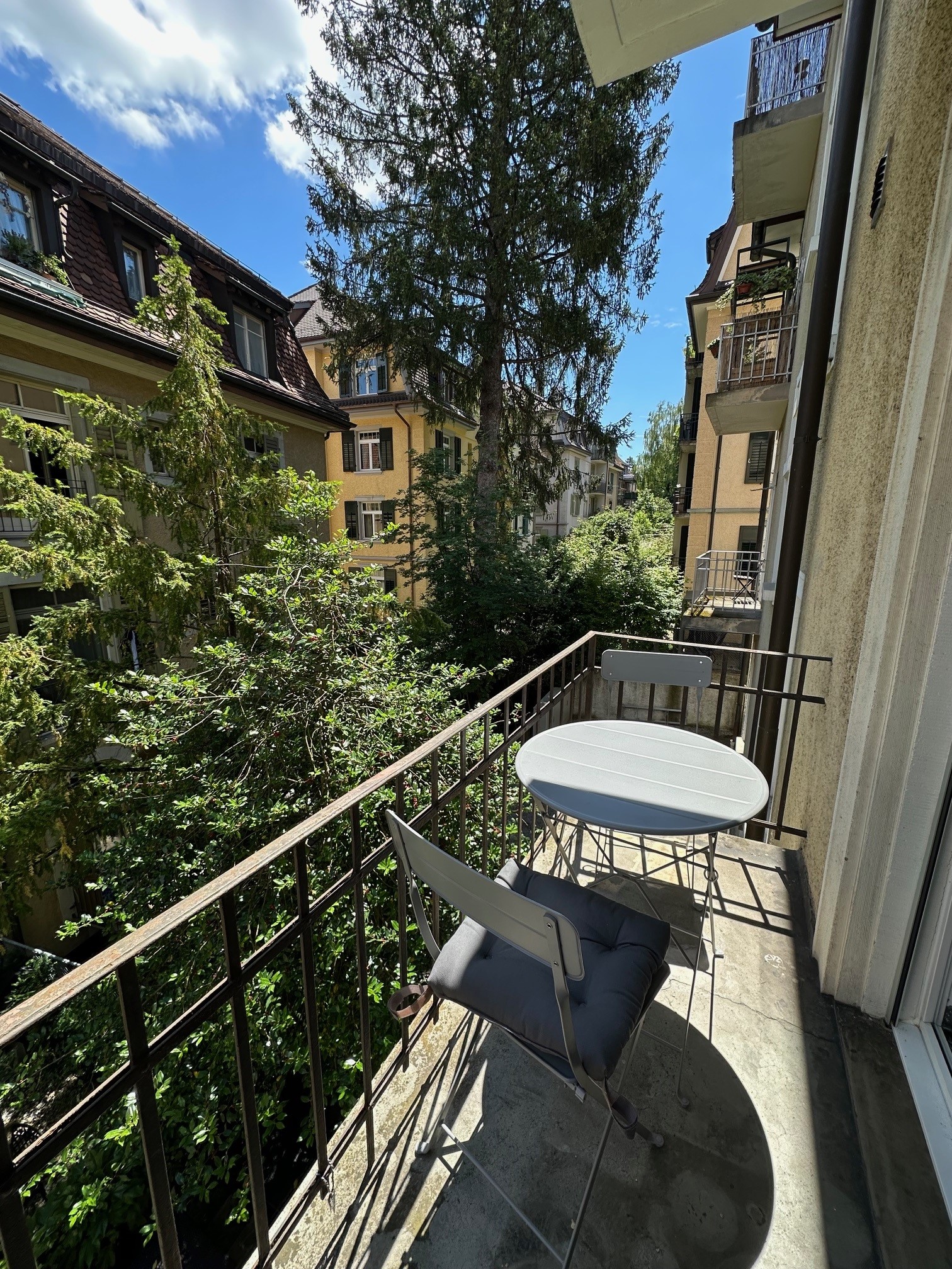 Balkon mit Blick in einen begrünten Innenhof