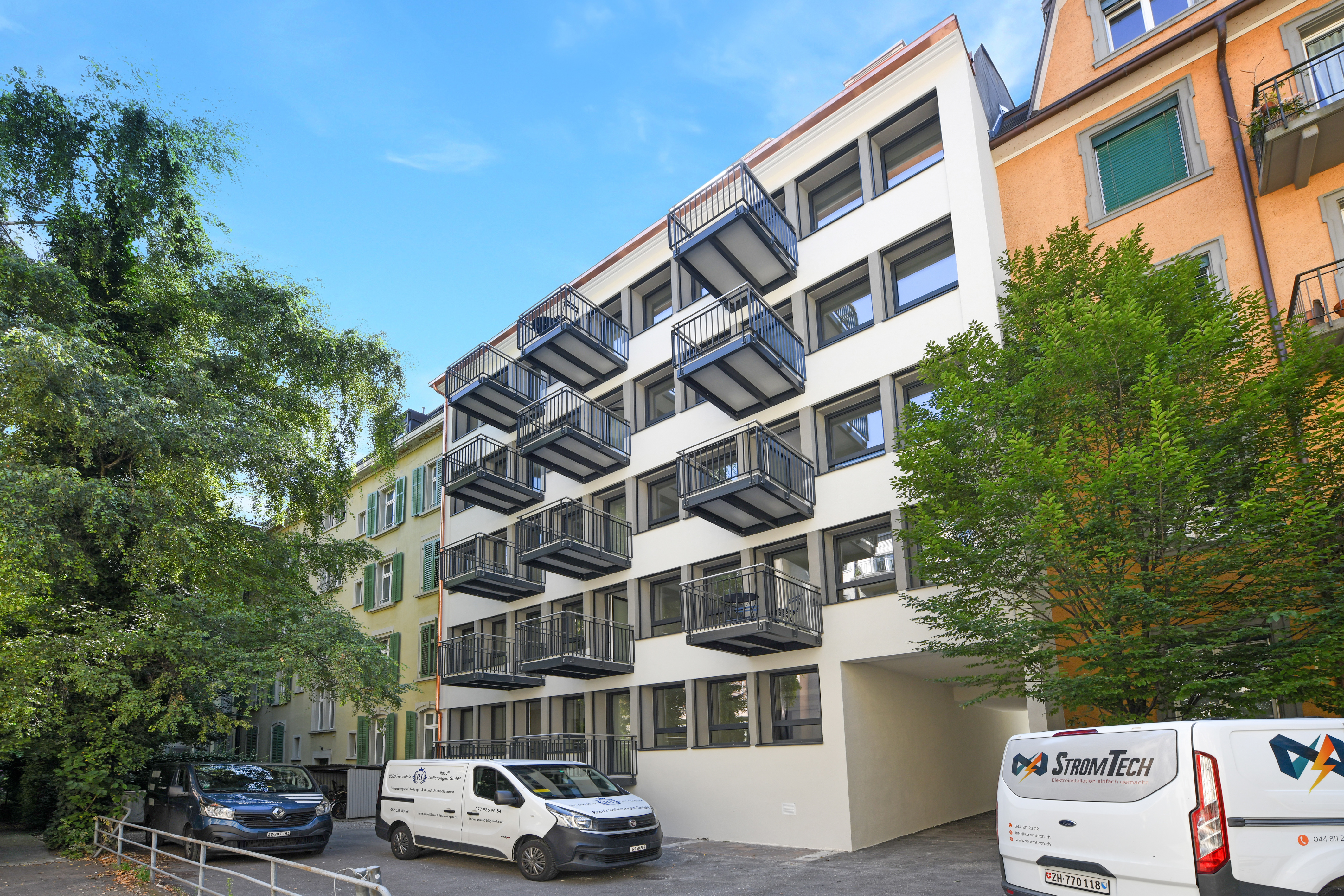 Mehrfamilienhaus mit Balkonen und Stadtgrün
