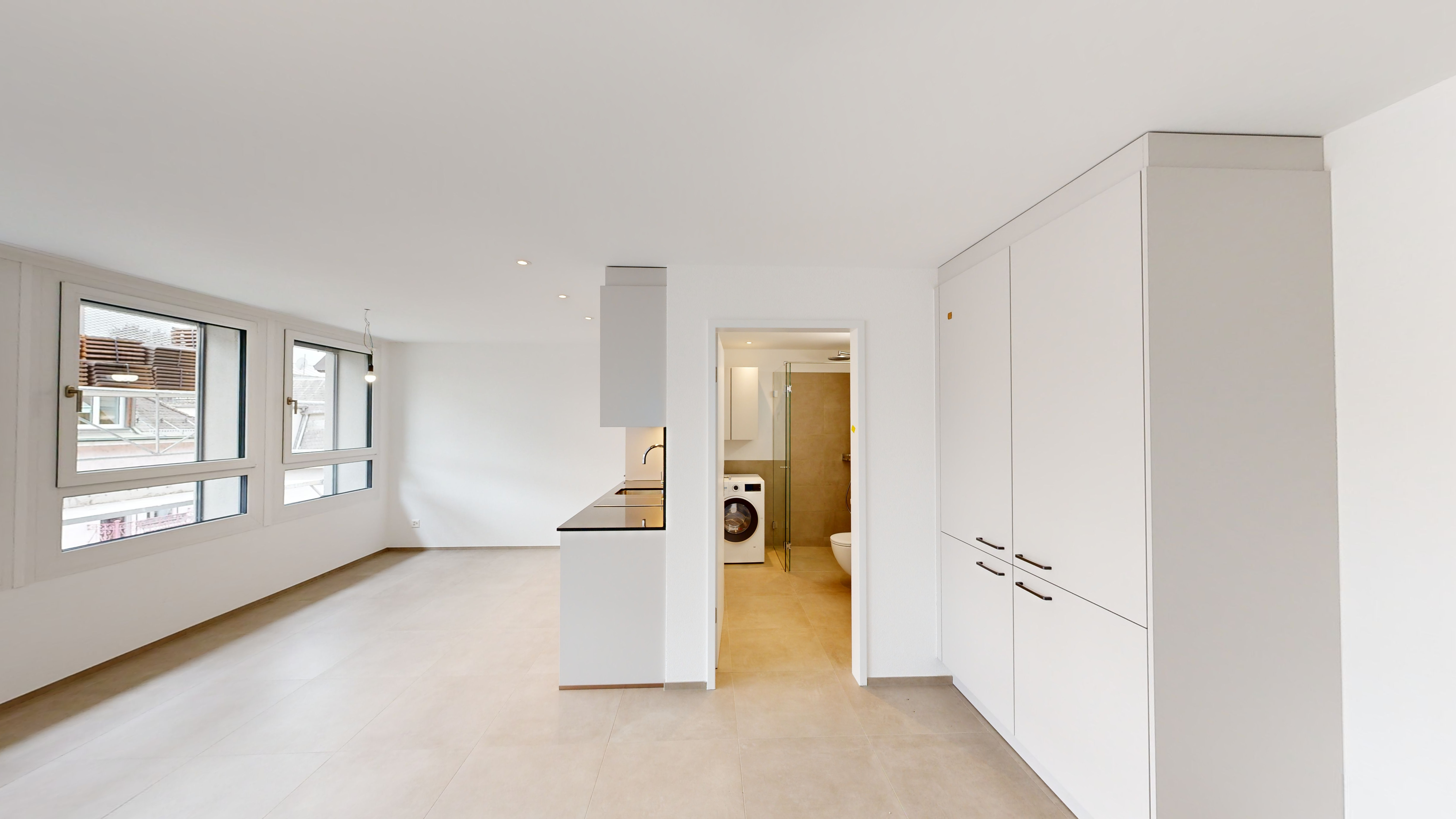 Heller, leerer Wohnbereich mit Fensterfront und Einbauschrank