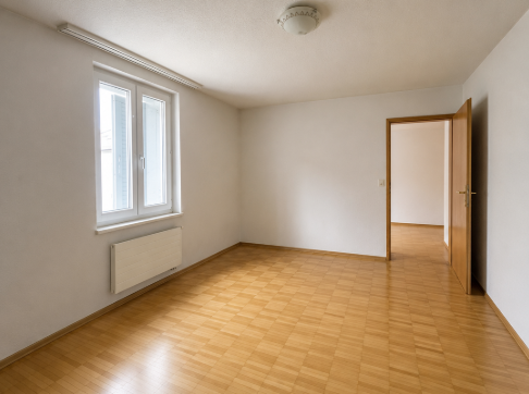 Leerer heller Raum mit Fenster und Holzboden