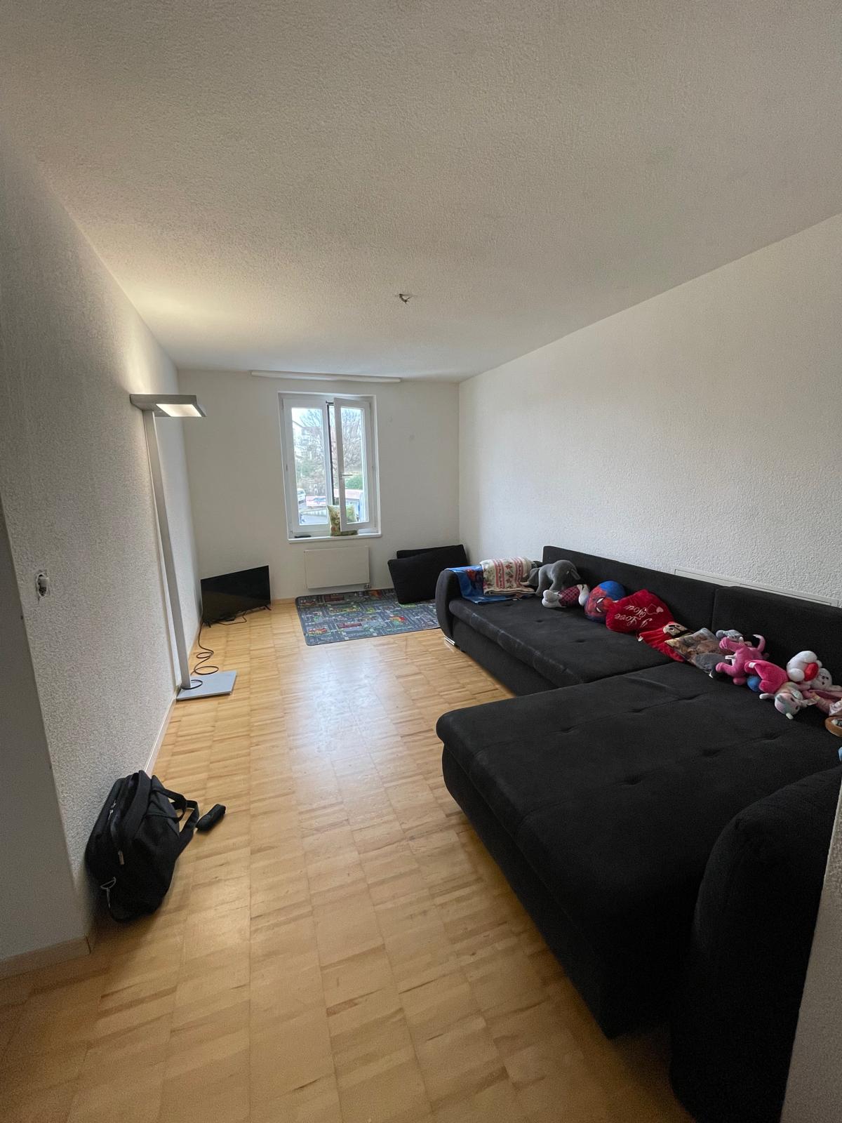 Schmales Wohnzimmer mit schwarzer Eckcouch