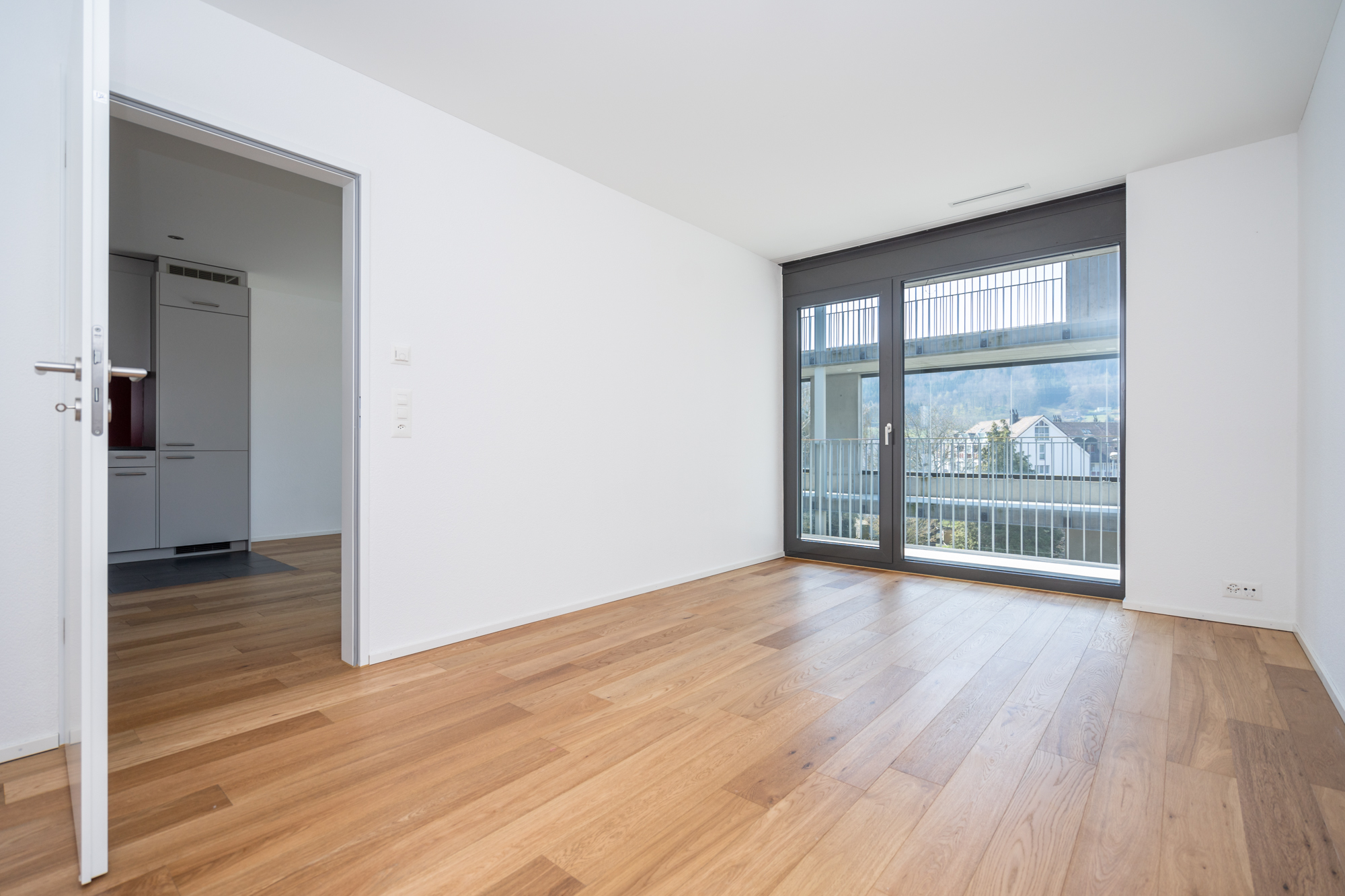 Heller leerer Wohnraum mit Balkonblick