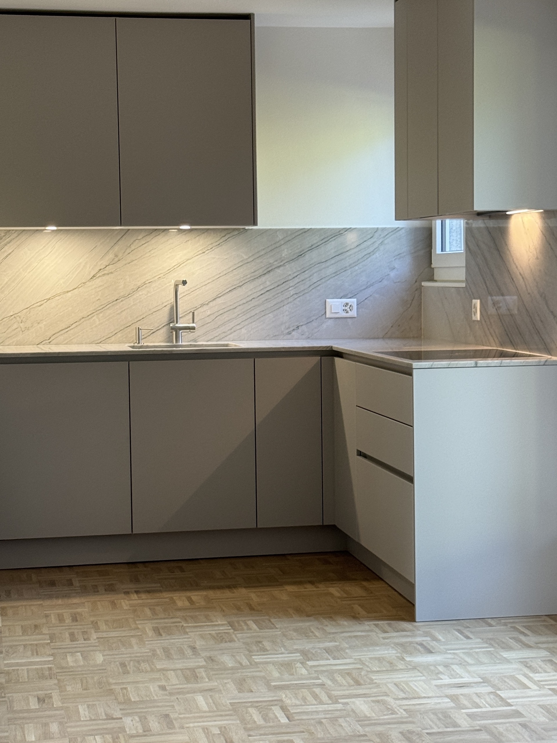 Moderne, leere Küche mit Natursteinrückwand