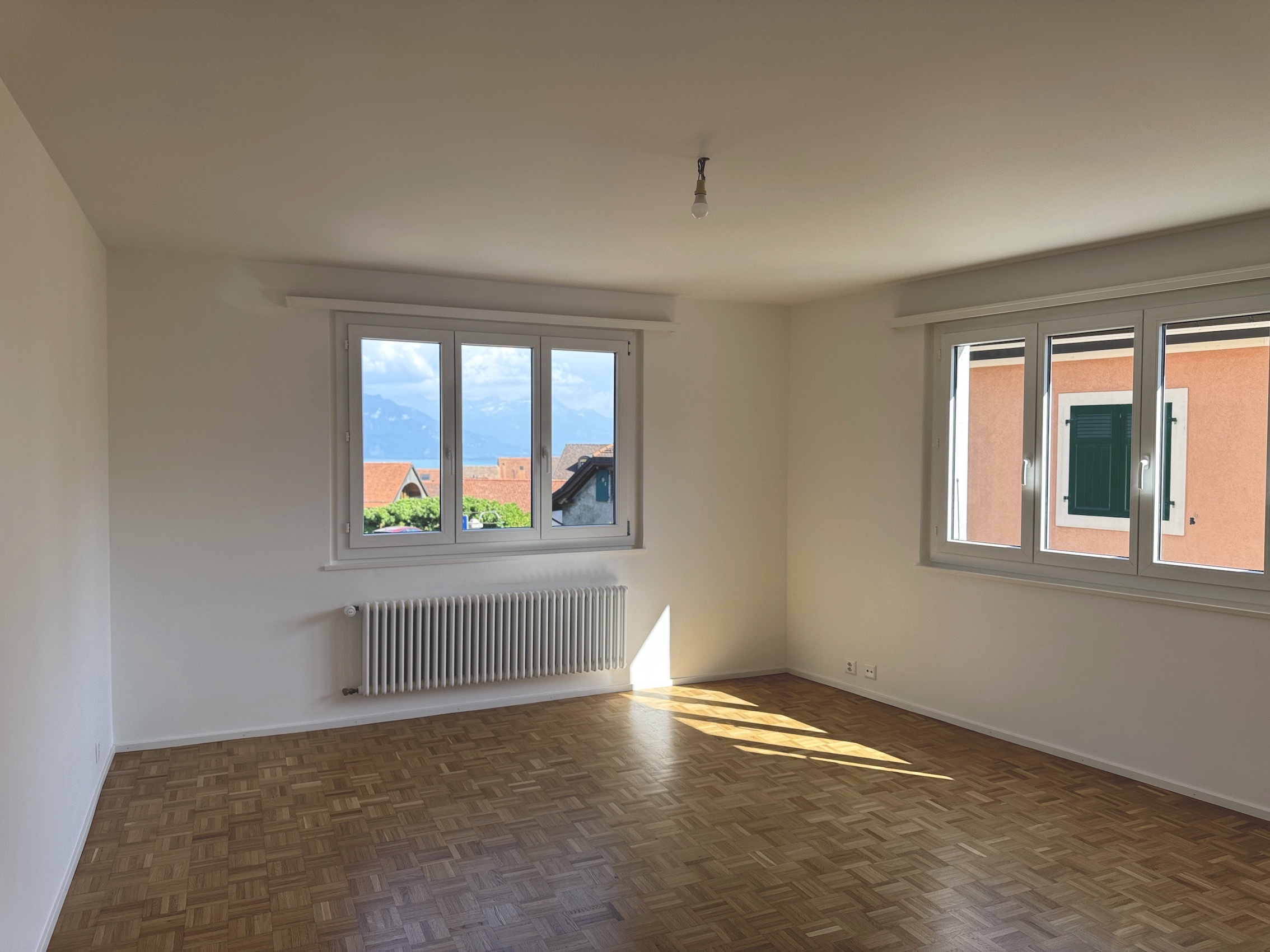 Leerer Wohnraum mit Parkett und Bergblick