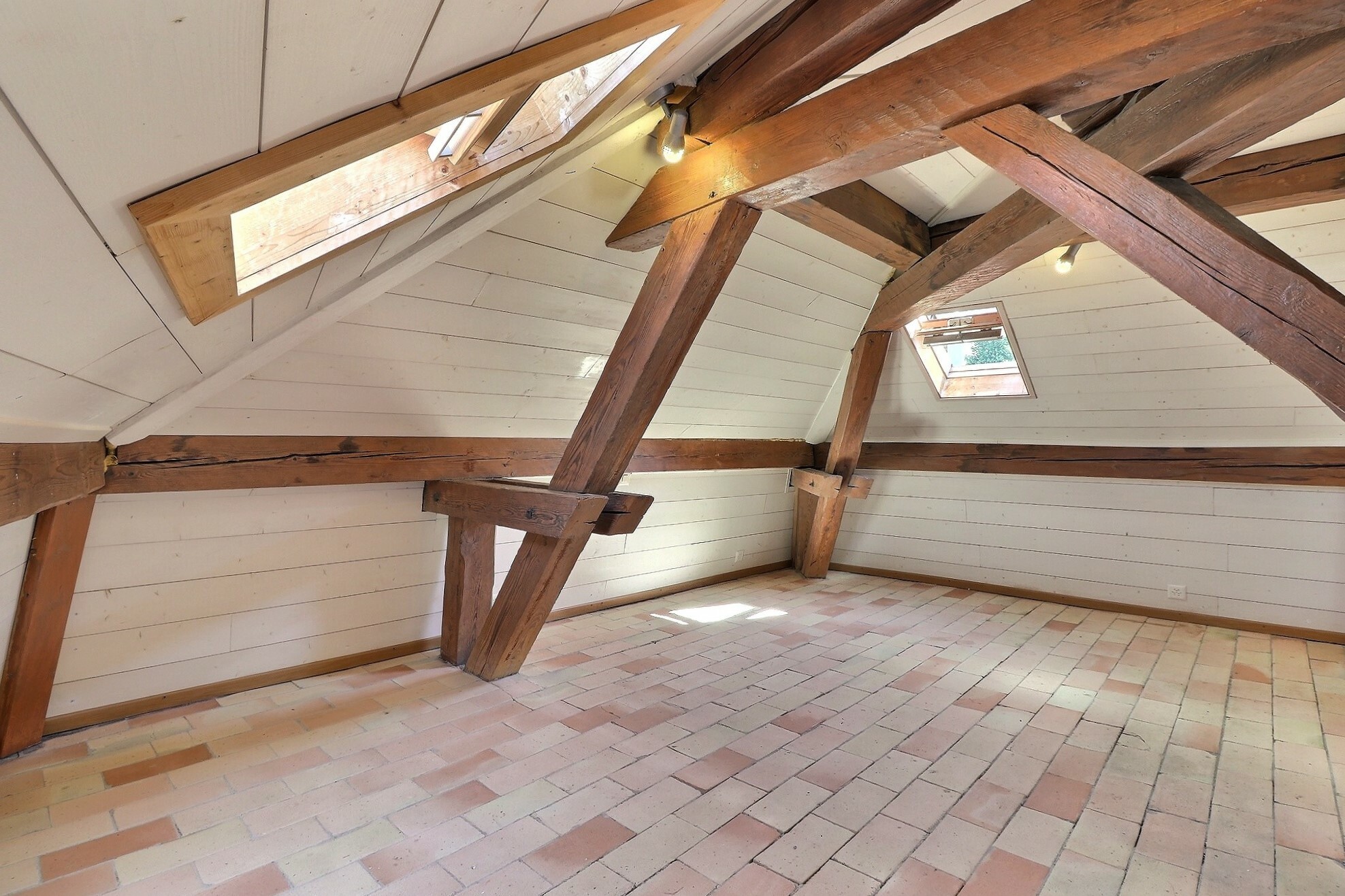 Dachgeschossraum mit sichtbaren Holzbalken