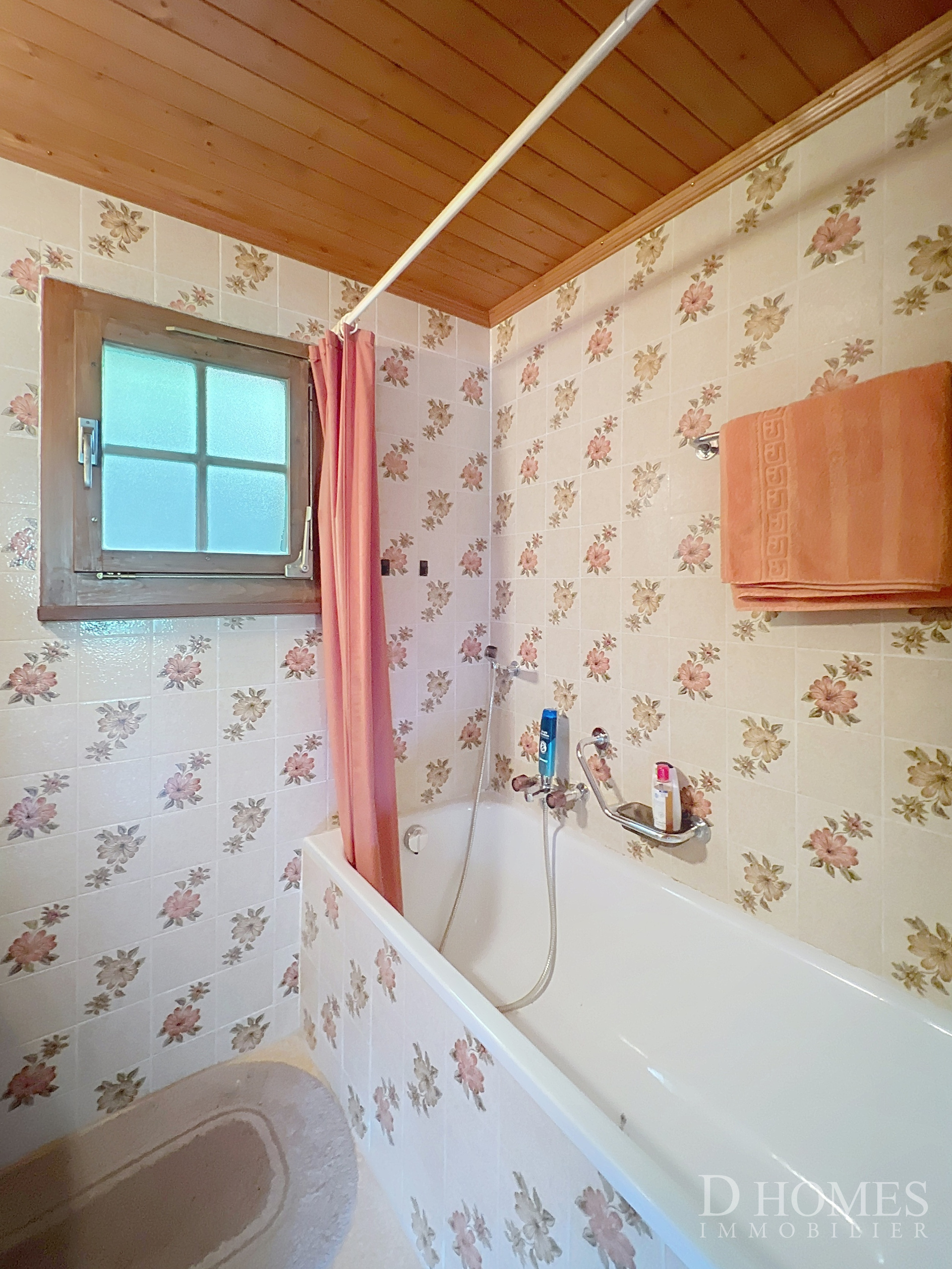 Badezimmer mit Badewanne und Blumenfliesen
