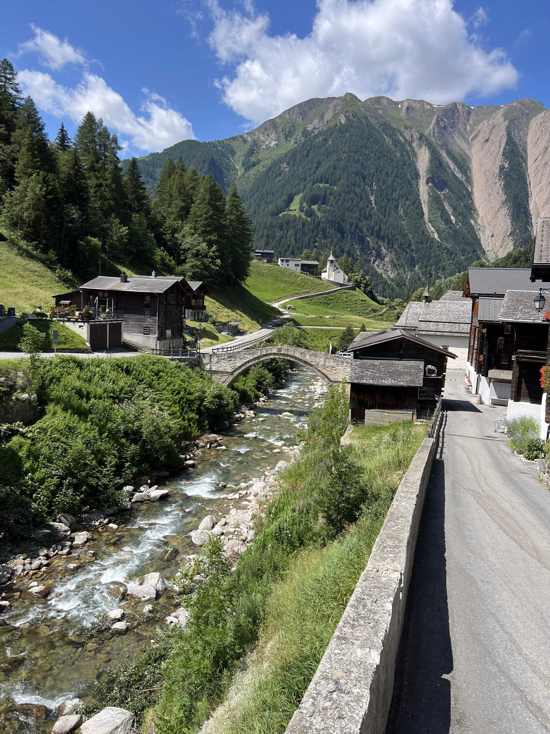 Alpines Dorf mit Fluss und Brücke