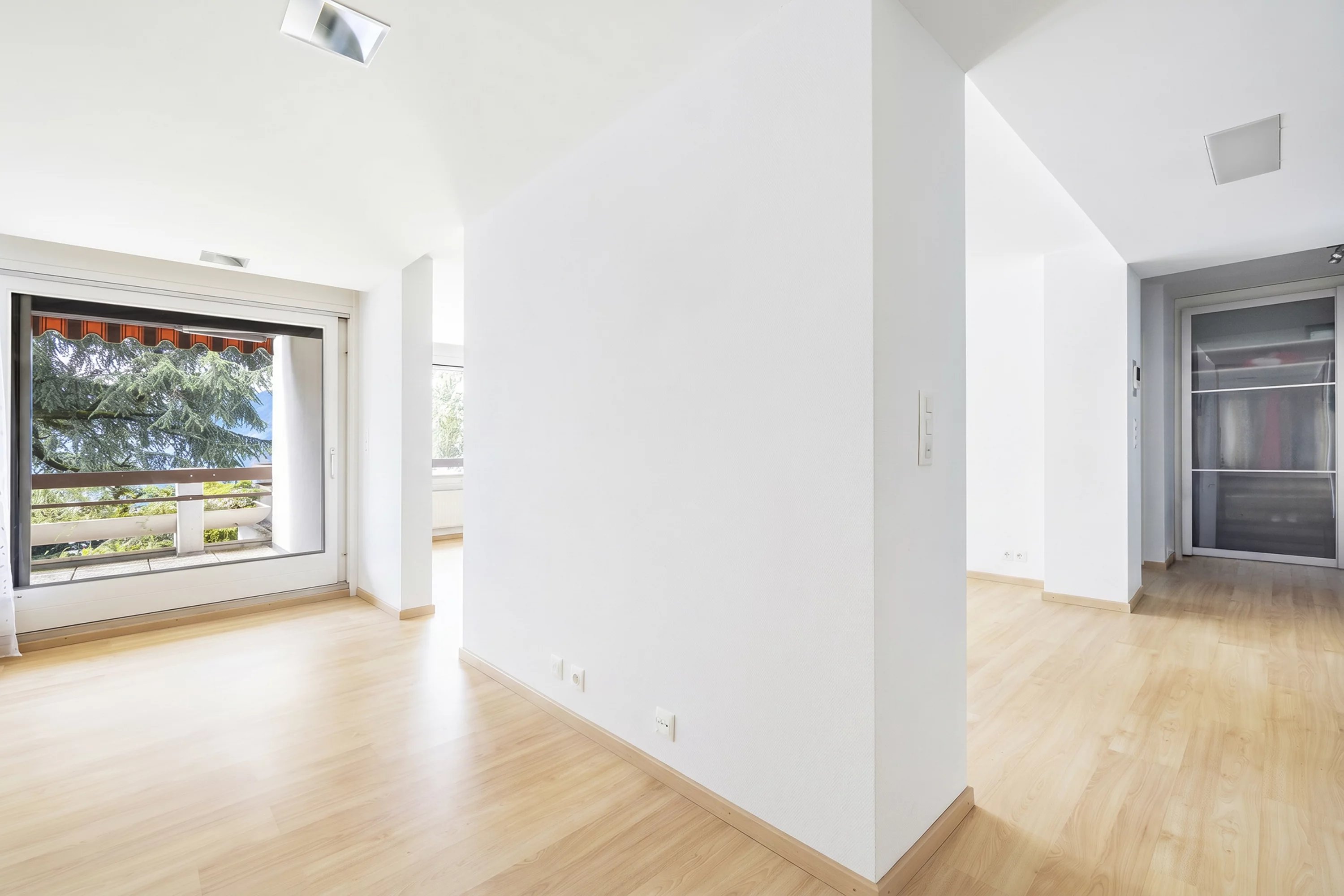 Helle, leere Wohnfläche mit Balkonblick