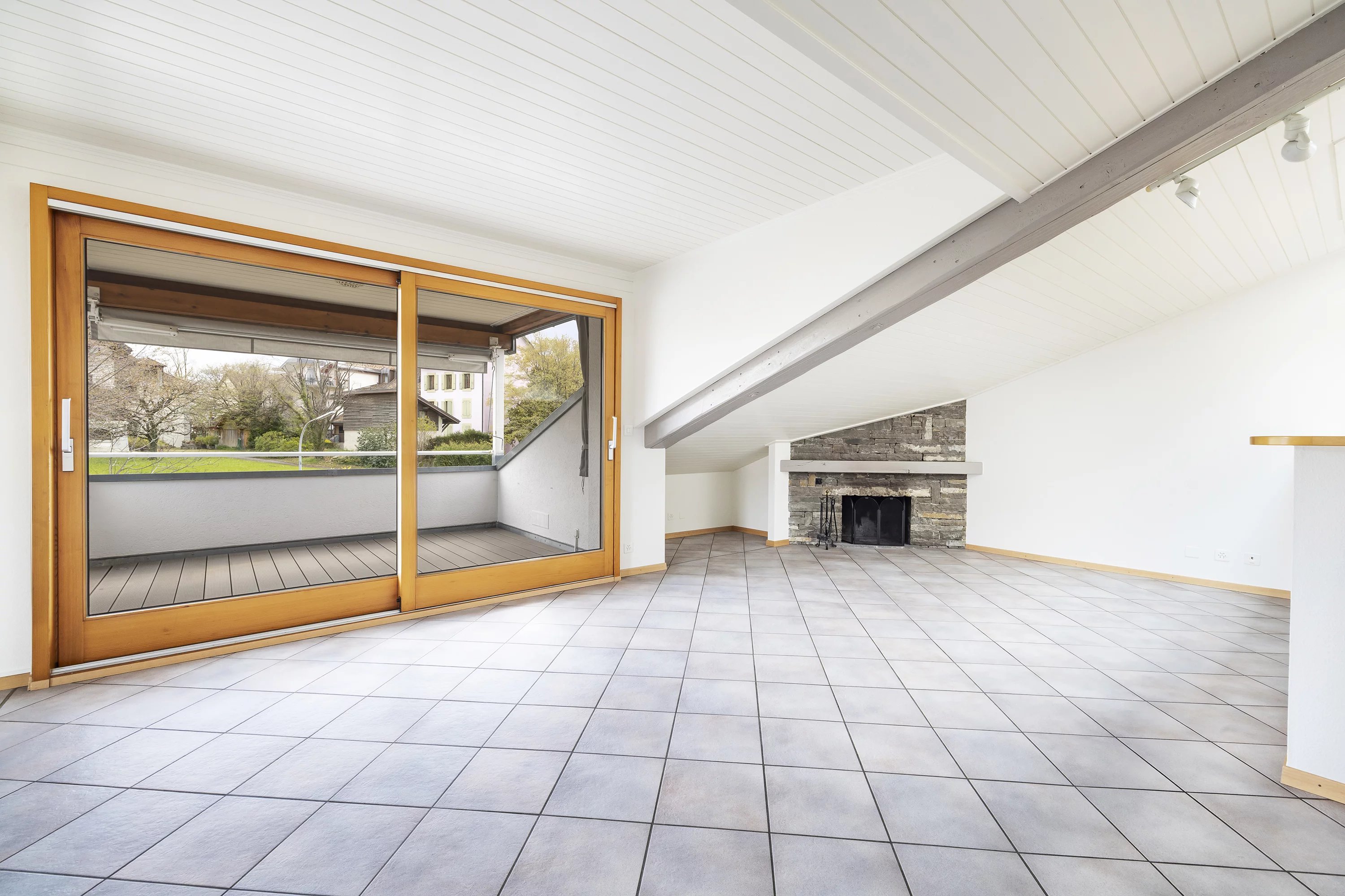 Heller Wohnraum mit Kamin und großer Fensterfront